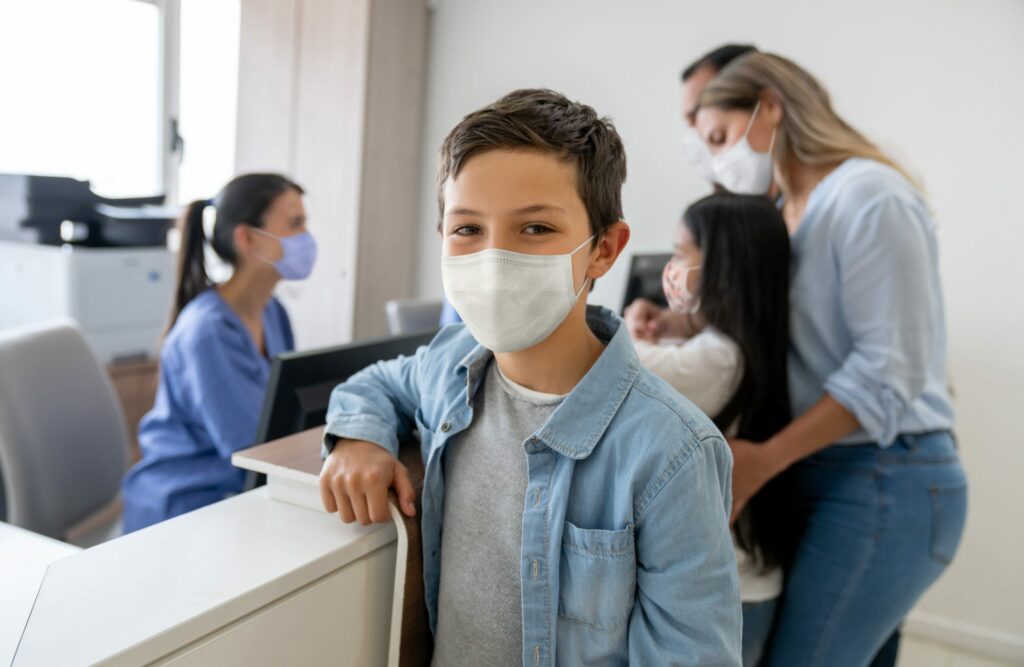 Happy boy at the reception of a hospital wearing a facemask